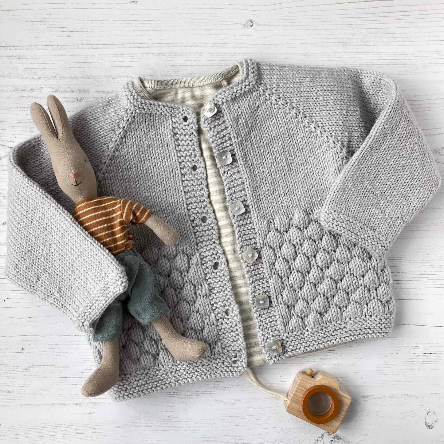 a knitted sample for a top down knitting pattern for a baby cardigan