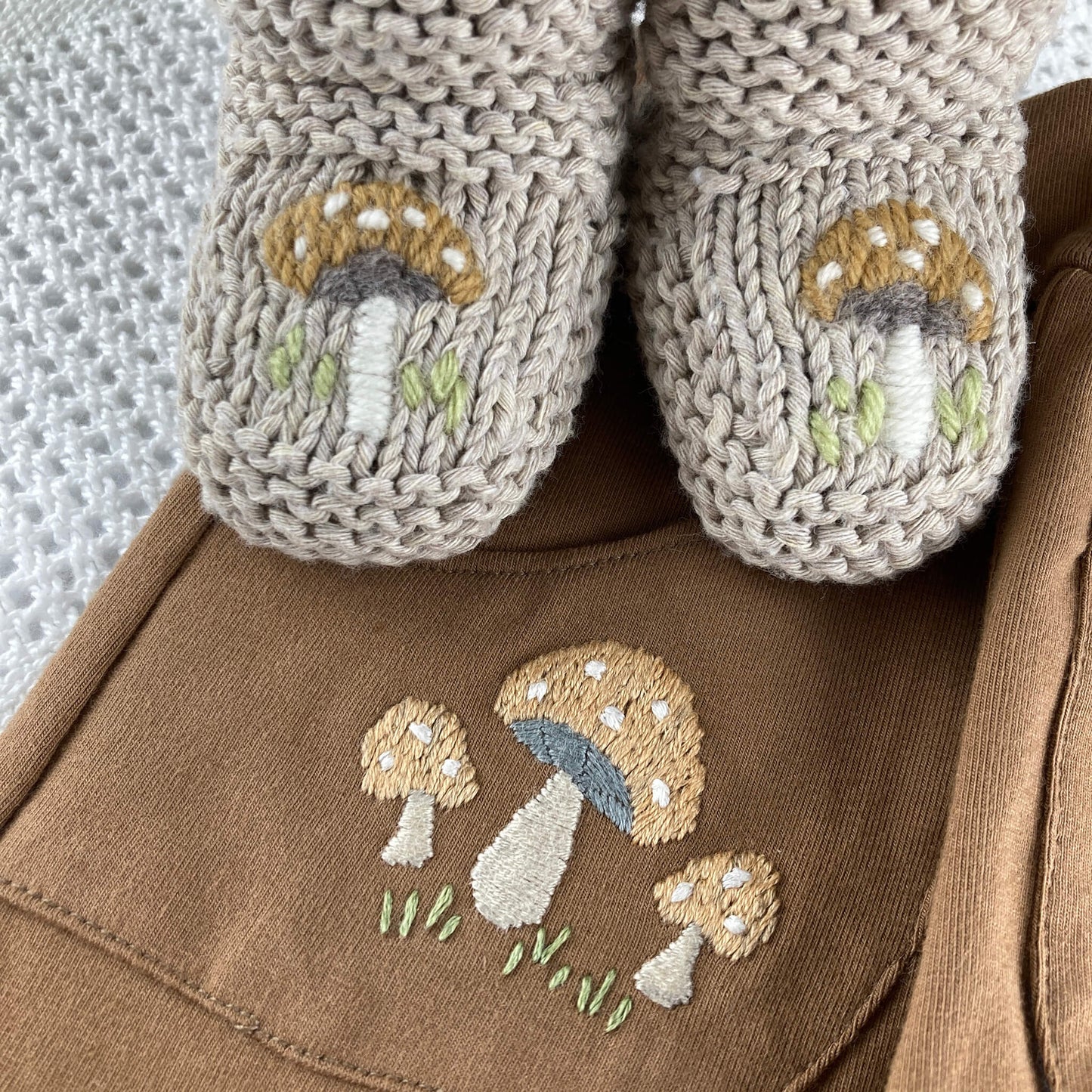 baby clothing embroidery pattern. toadstools embroidery is shown on booties and joggers