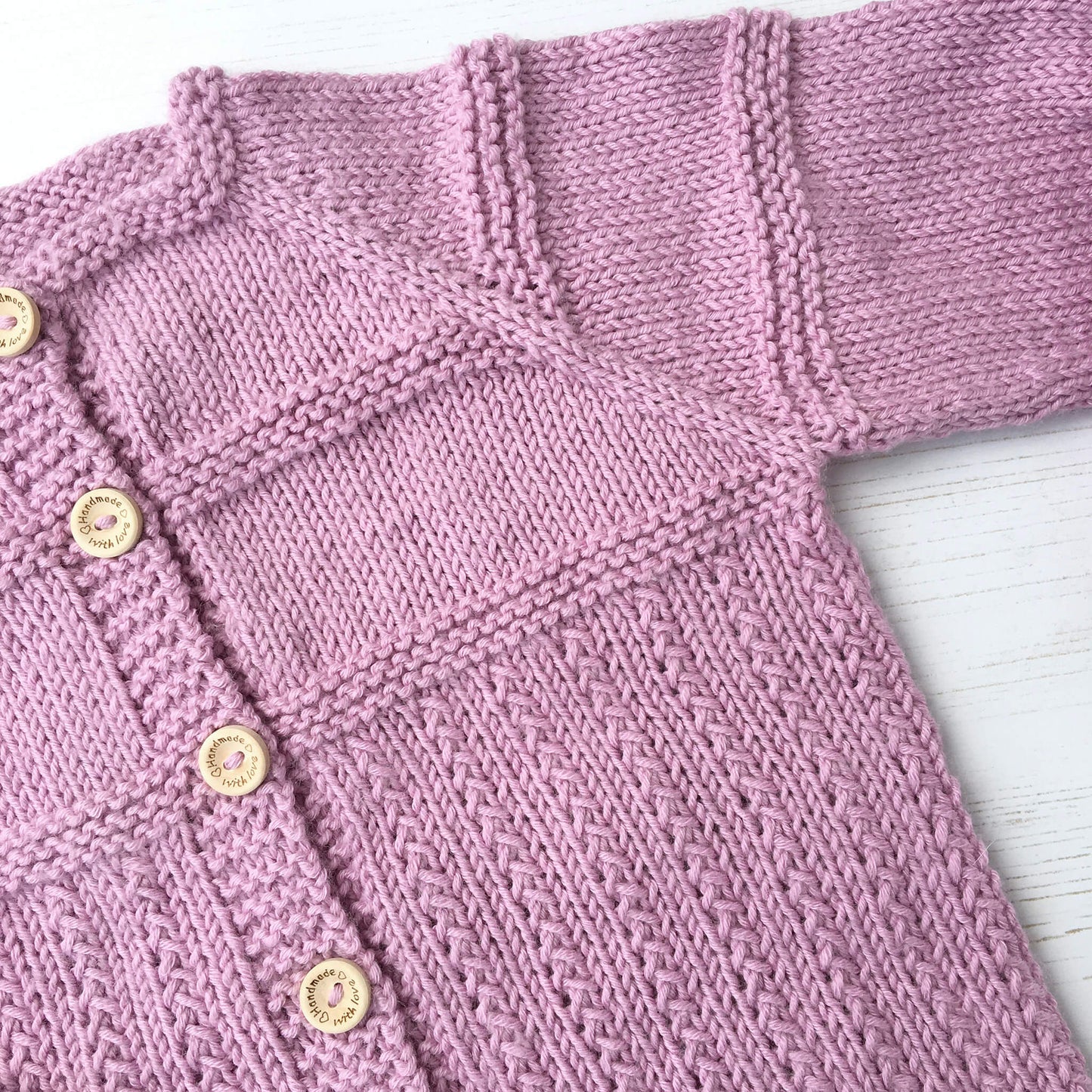 a knitting pattern for a baby cardigan. photo is showing a close up of the design