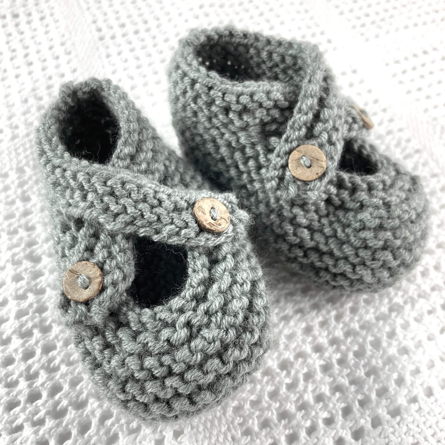 a knitting pattern for baby shoes with crossover starps