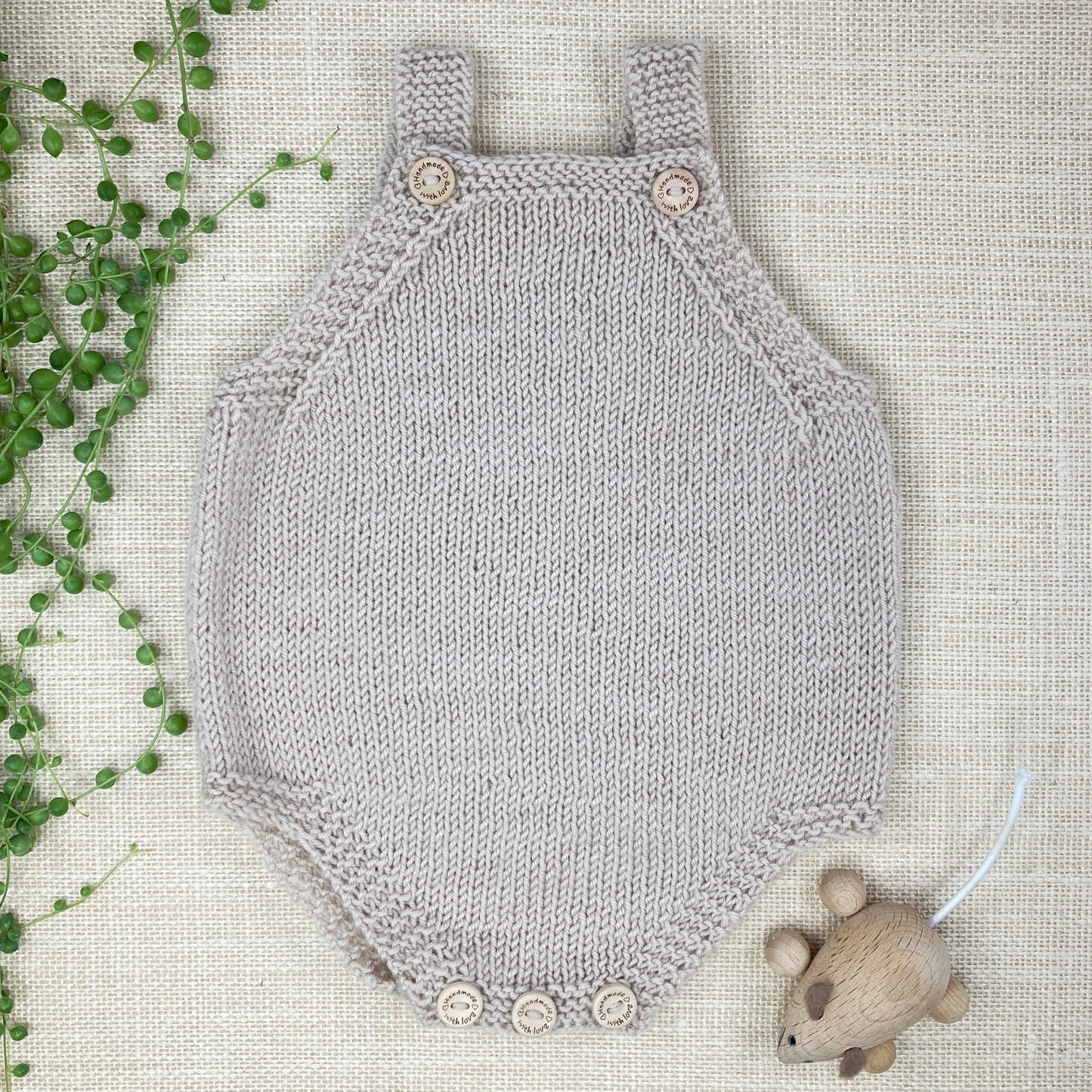 an easy knitting pattern for a baby romper, sample is shown in light grey