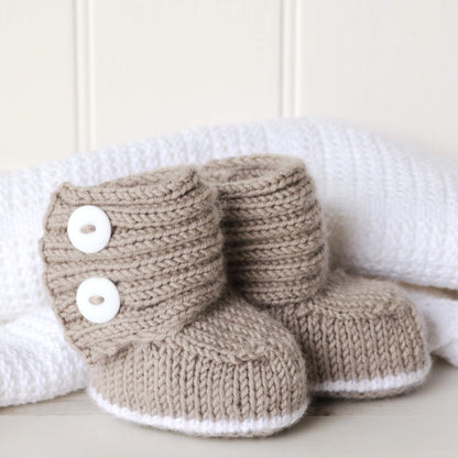 a baby booties knit pattern shown against  white blankt and wall