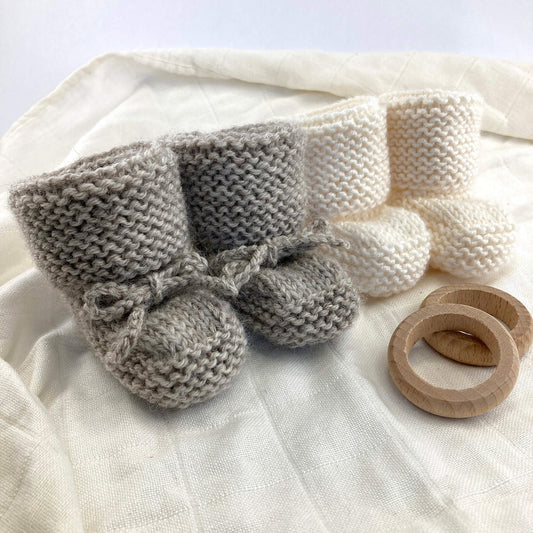 2 samples for baby booties knitting pattern showing pair with knitted ties and one pair without