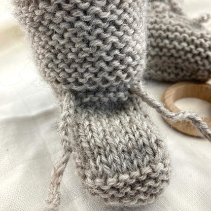 close up photo of baby booties knitting pattern showing the knitted ties in detail