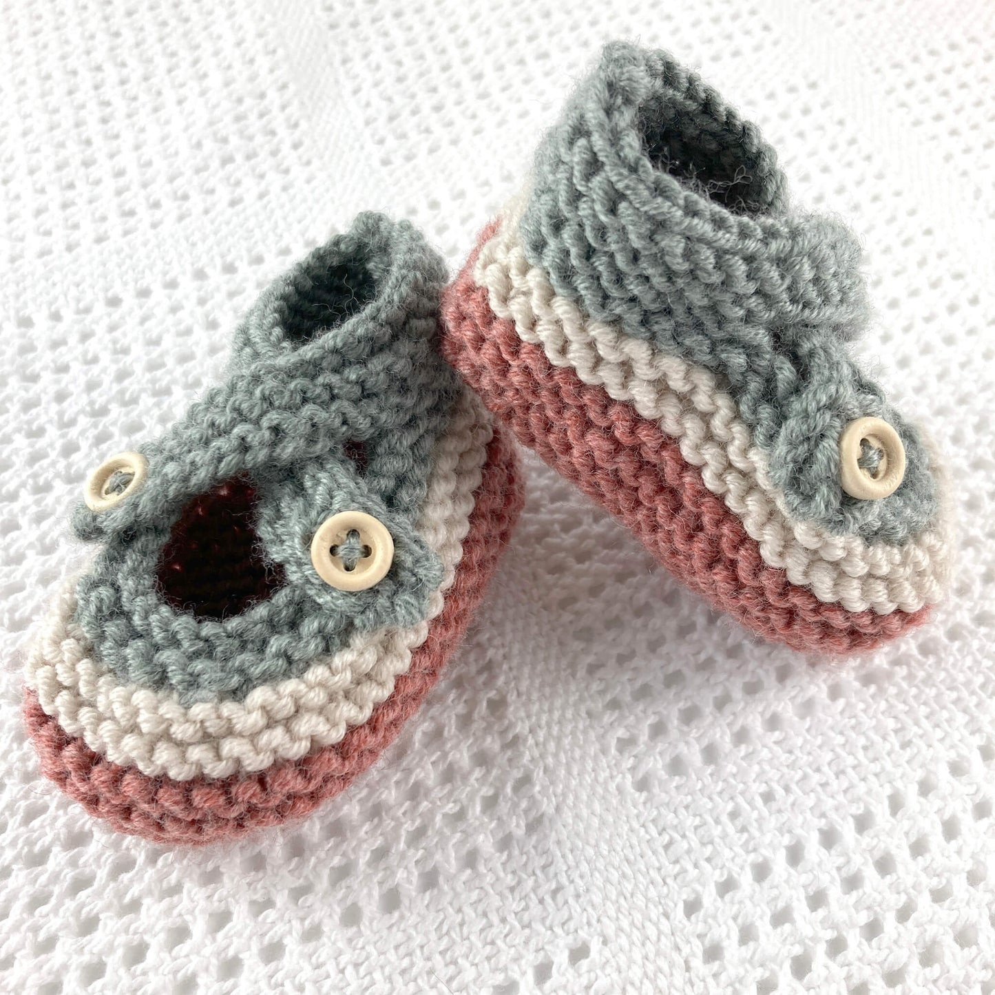 an easy baby booties knitting pattern. booties are knit in  colours and have crossover straps and button fastening