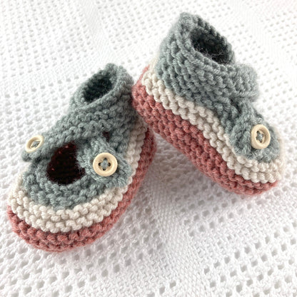 an easy baby booties knitting pattern. booties are knit in  colours and have crossover straps and button fastening