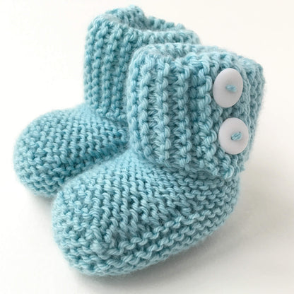 an easy baby booties knitting pattern. the booties have a fold over cuff and the sample shown are knit in turquoise yarn