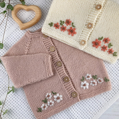 baby cardigan knitting pattern with floral embroidery on a white blanket