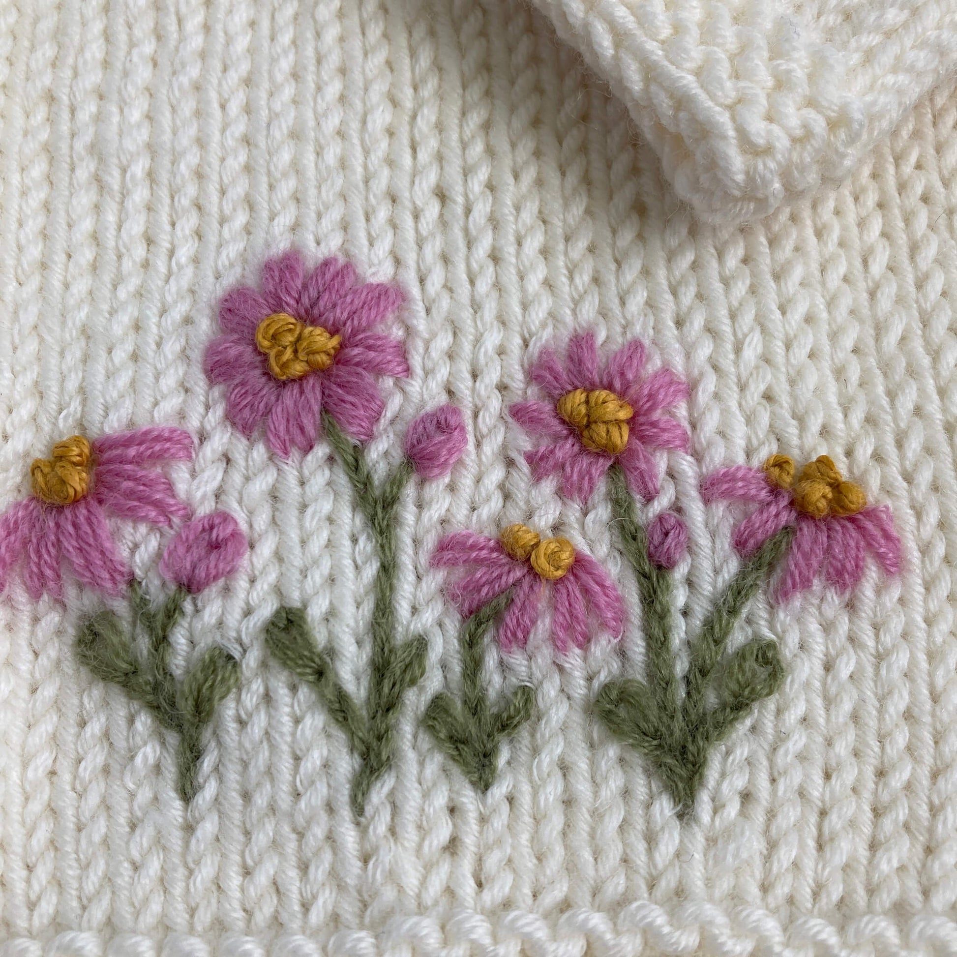 a close up photo of a flower embroidery pattern for baby clothing