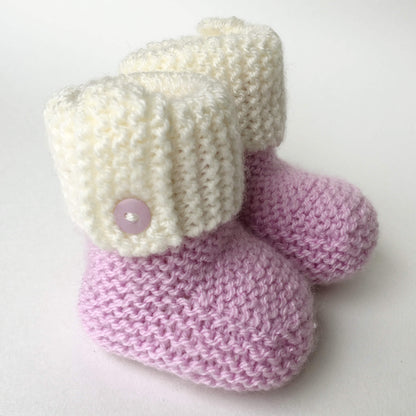 a booties knitting pattern shown with a pink  foot section and a white cuff