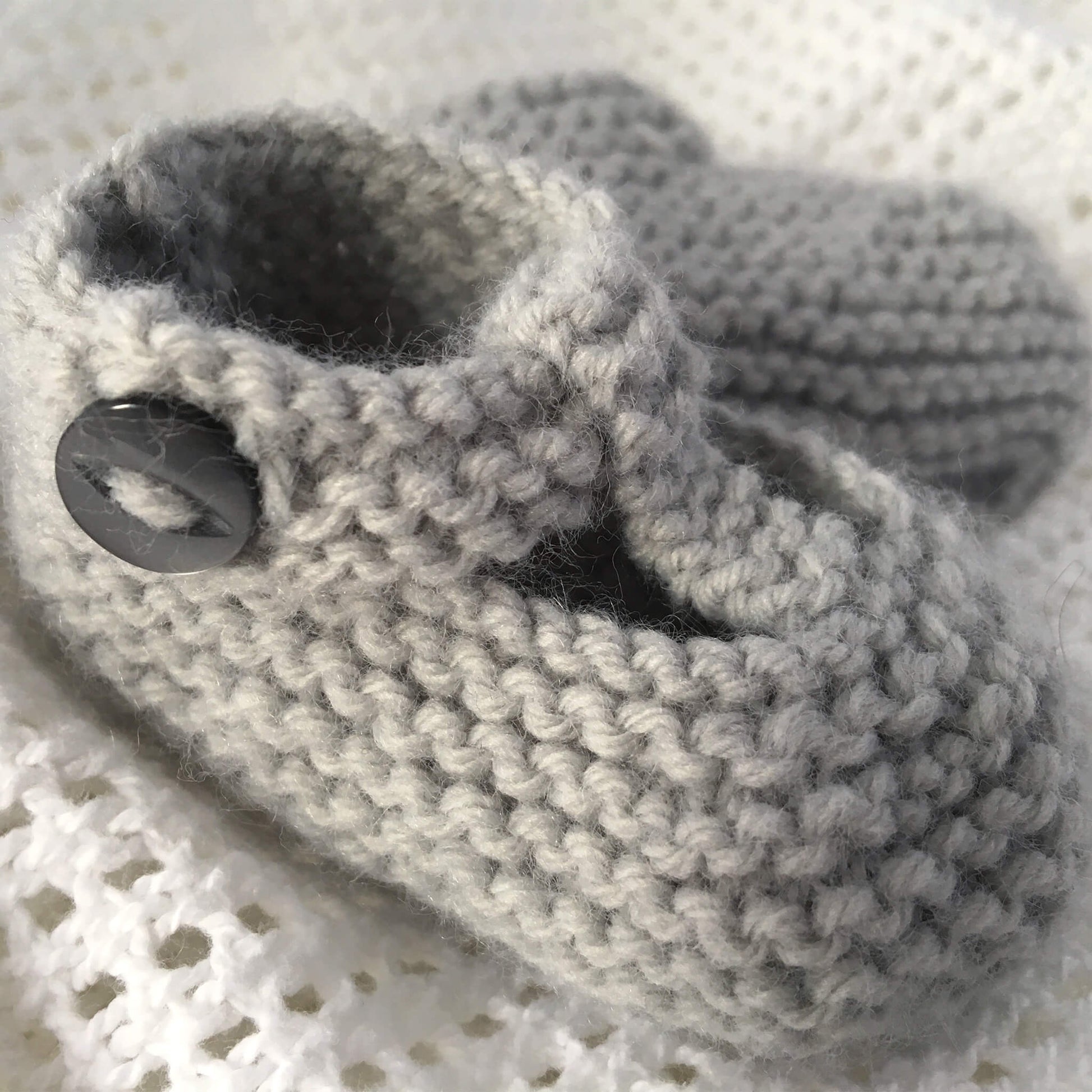 a knitting pattern for baby booties with buttons